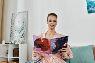 Çarpıcı bir travesti moda dergisi okurken rahatlar..
