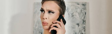 Şık, genç bir travesti telefonda düşünceli bir şekilde poz veriyor..