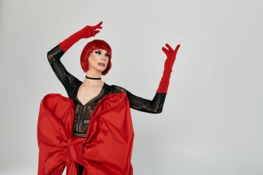 Göz kamaştırıcı bir travesti dikkat çekici bir kırmızı elbiseyi zarafet ve güvenle sergiliyor..