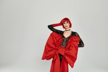 Çarpıcı bir travesti kendine güvenen ve yetenekli kırmızı bir görünüm sergiliyor.