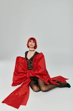 Çarpıcı drag queen canlı bir stil ve kendine güven sergiliyor cesur kırmızı zarafetle.