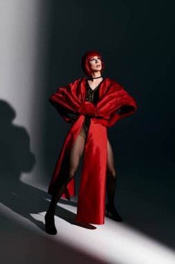 Kendine güvenen bir travesti çarpıcı kıyafetlerini sergiliyor ve etkileyici bir şekilde poz veriyor..