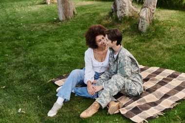 A joyous return as a soldier embraces her wife in a heartfelt reunion outdoors. clipart