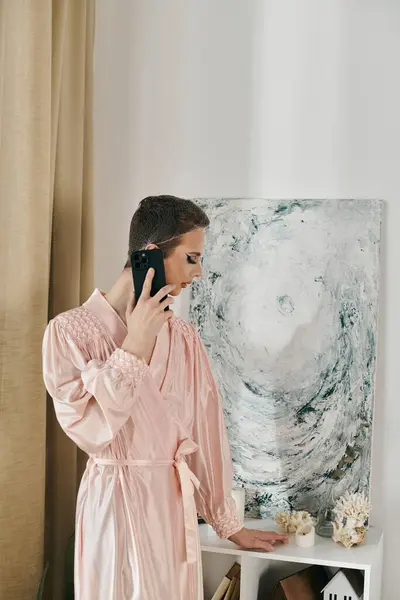 stock image A young drag queen poses elegantly while holding a phone.