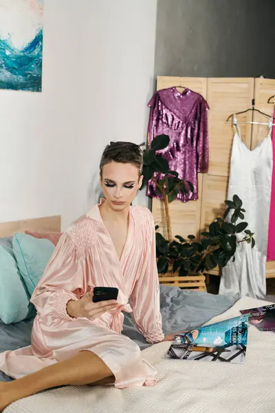 stock image A stunning drag queen enjoyingly interacts with their phone on a cozy bed.