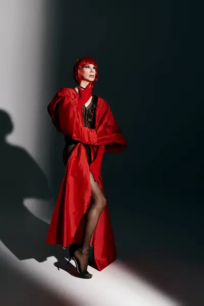 stock image An attractive drag queen showcases confidence and style in a striking red outfit.