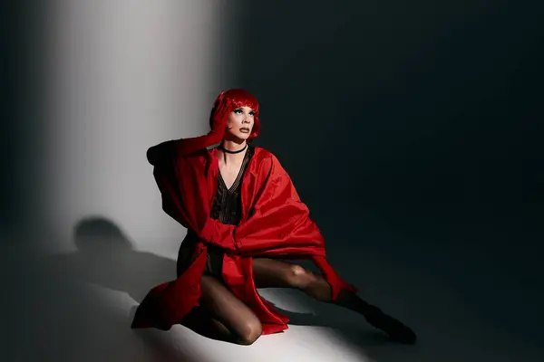 stock image An attractive drag queen exudes confidence while striking a pose in vibrant red attire.