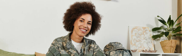 Гордая молодая женщина в военной одежде улыбается, когда готовится отправиться в свое служебное путешествие.