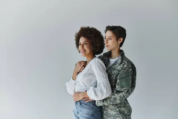 Stock image A loving farewell moment between a soldier and her wife in a cozy studio environment.