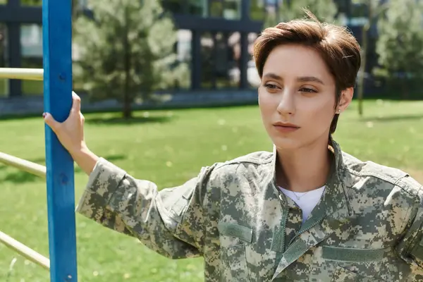 stock image A young woman in camouflage after returning home from military service.