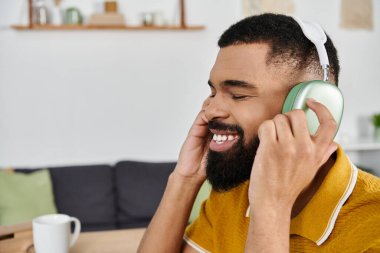 Neşeli bir adam, rahat bir yerde dinlenirken müzik dinler..