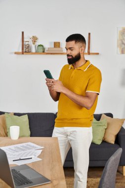 Şık bir adam evde özel vakit geçirir, akıllı telefonuna odaklanır..