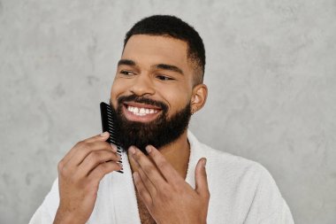 A cheerful man combs his beard while enjoying his morning at home. clipart