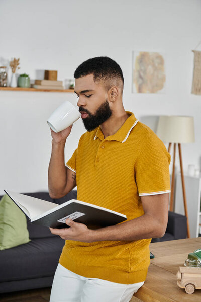 A stylish man sips coffee and reads attentively in a warm, inviting space.