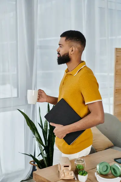 Stock image A relaxed man savors his coffee while pondering in a comfortable setting.