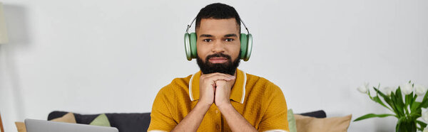 A man is immersed in music, enjoying a tranquil moment at home.