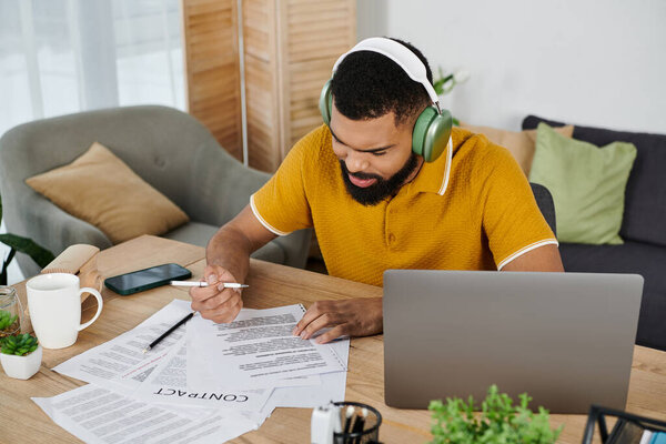 Мужчина концентрируется на бумажной работе на своем уютном домашнем рабочем месте.