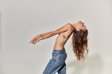 Kendine güvenen genç bir kadın zarif bir şekilde vücudunu narin giysiler içinde gösterir..