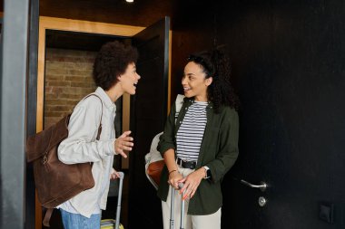 Two happy travelers share a moment of excitement while exploring their hostel. clipart