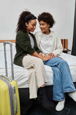 A joyful couple enjoys intimate moments in their hotel room, sharing smiles and laughter together. clipart