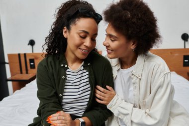 Neşeli bir çift, otel odalarında dinlenirken kahkaha ve şefkat paylaşır..