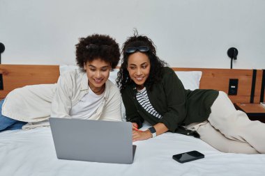 Keyifli bir çift otel yatağında dinlenirken seyahat planlarını keşfeder, kahkaha ve bağlantılarını paylaşırlar..