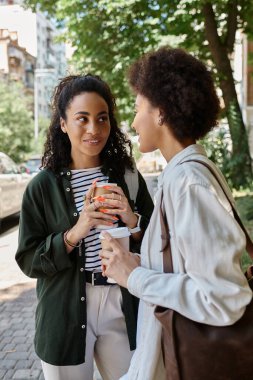 Neşeli bir çift, güneşli bir günde açık havada sohbet eder ve kahve içer..