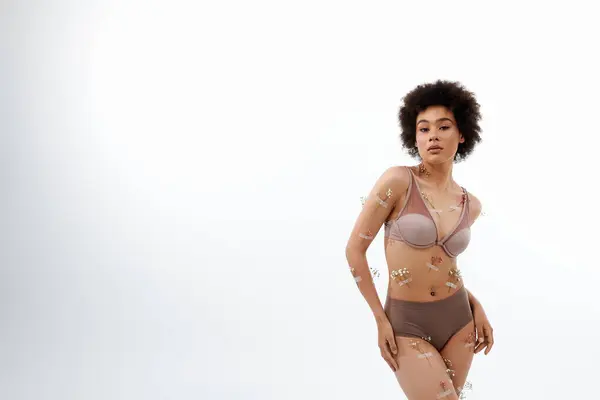 stock image Good looking curly haired woman posing with flowers on body and underwear.