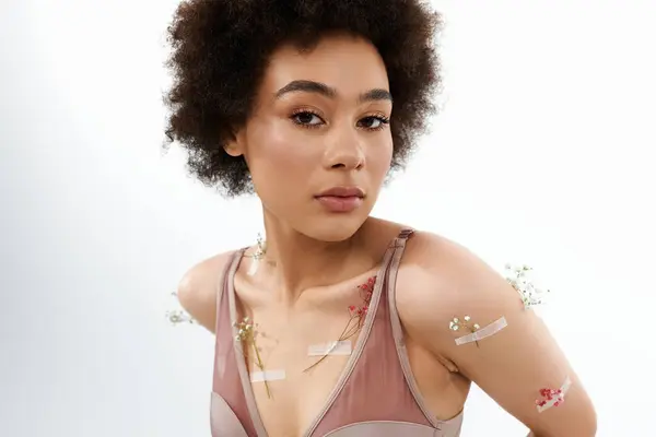 stock image Elegant curly haired woman posing with flowers on body and underwear.