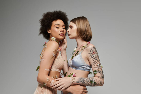 Two women share a tender moment, beautifully adorned with flowers.