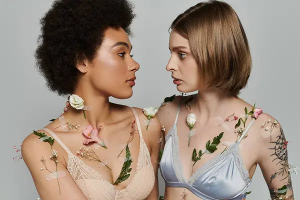 stock image A beautiful lesbian couple shares a tender glance, embellished with floral accents.