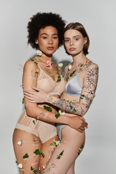 A loving couple embraces, adorned with flowers and leaves in a serene setting.