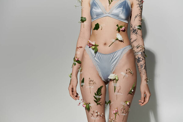 Молодая женщина с растениями на теле в нижнем белье.