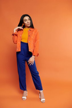 Kendine güvenen bir kadın şık duruşu olan parlak renklerde moda sergiliyor..
