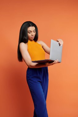 Şık bir kadın laptopuyla düşünceli bir şekilde iletişim kurar, kendine güveni vardır..