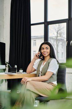 Modern bir iş yerinde şık, profesyonel bir kadın telefonuyla konuşuyor..