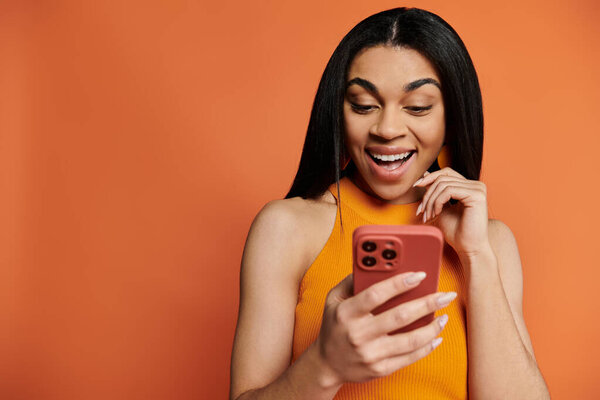 A delighted woman interacts with her smartphone, expressing excitement and joy.