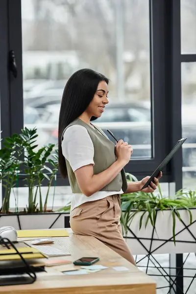 stock image Focused woman analyzing ideas in a bright, plant filled workspace.