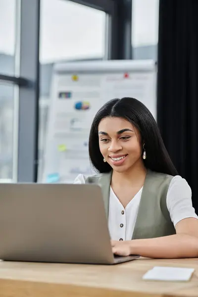 stock image Smiling woman engaged in work at a contemporary office desk.