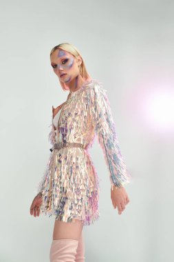 Tarz sahibi genç bir kadın ışıltılı detaylarla birlikte holografik bir ortamda cazibe yayar..