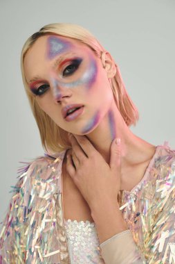 Şık bir genç kadın canlı makyaj ve holografik moda öğeleri sergiliyor..