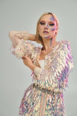 Şık bir genç kadın canlı holografik giysiler ve büyüleyici bir makyaj sergiliyor..