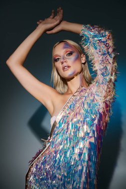 Şık bir genç kadın, çarpıcı pozlar ve renkli makyajla holografik moda sergiliyor..