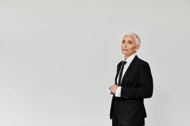 Kısa saçlı olgun bir kadın moda anlayışını özgüvenle sergiliyor..