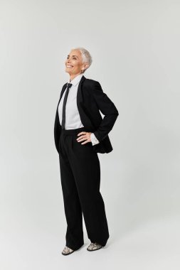 A chic woman exudes confidence in a tailored black suit, showcasing her unique style. clipart