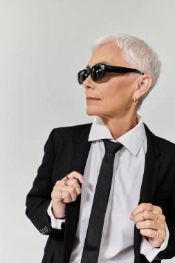Kendine güvenen olgun bir kadın şık elbisesini zarafet ve duruş ile sergiliyor..
