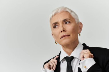 Kendine güvenen, olgun bir kadın şık kıyafetlerini göstererek gösteriş yapar..