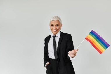 Şık bir kadın gururunu ifade eden gökkuşağı bayrağını neşeyle sallıyor..