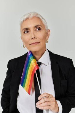 Şık giyinmiş kendine güvenen kadın, LGBTQ haklarına verdiği desteği gururla gösteriyor..