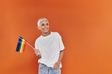 Gökkuşağı bayrağı tutan kısa saçlı bir kadınla neşeli bir an..